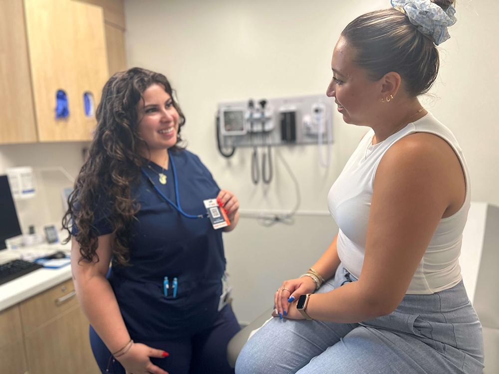 Health care professional showing badge to patient in medical exam room